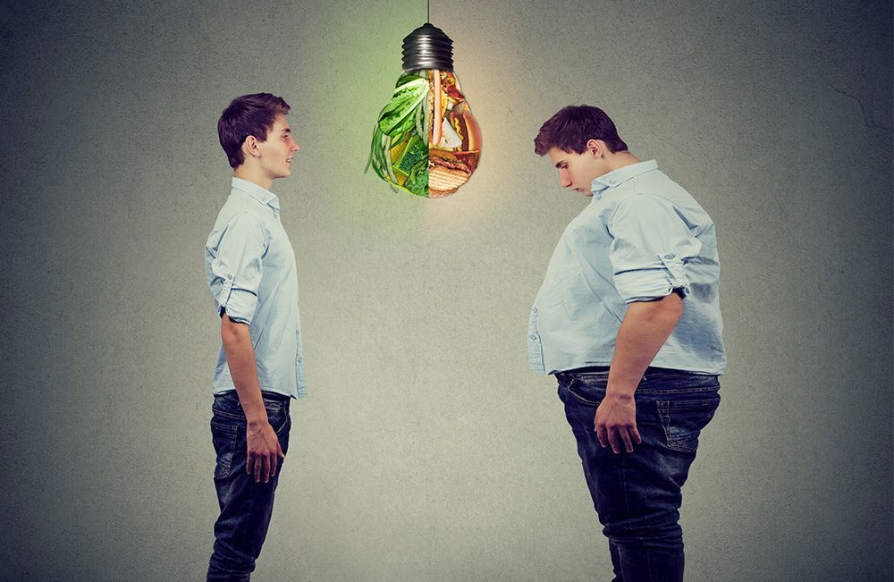 Two men are standing next to each other in front of a light bulb.