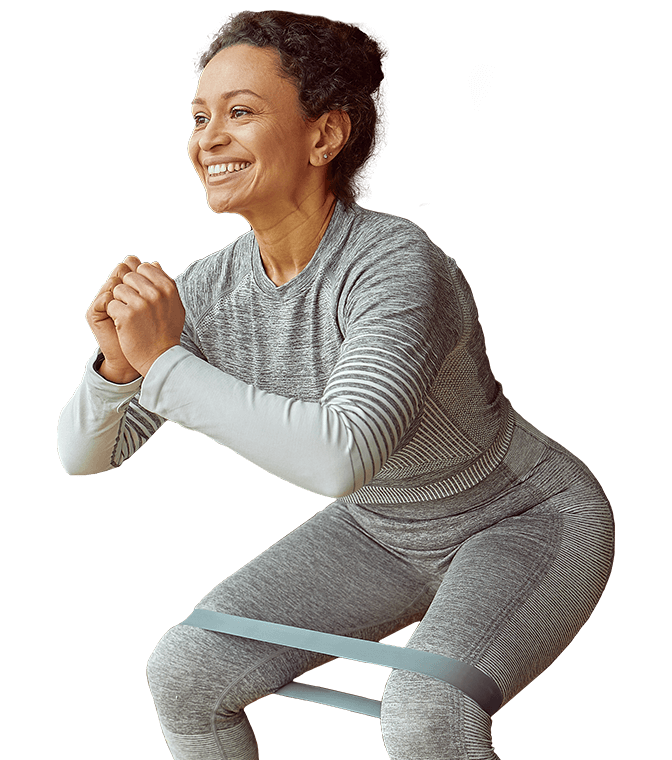 A woman is squatting with a resistance band around her waist.