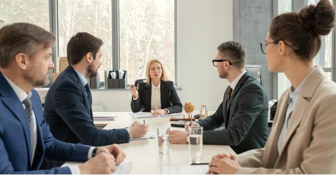 People in suits sitting at a conference table having a meeting