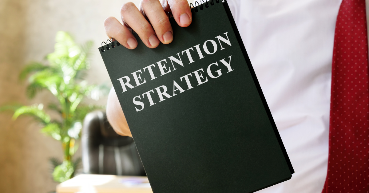 Person holding a notebook titled 'Retention Strategy'