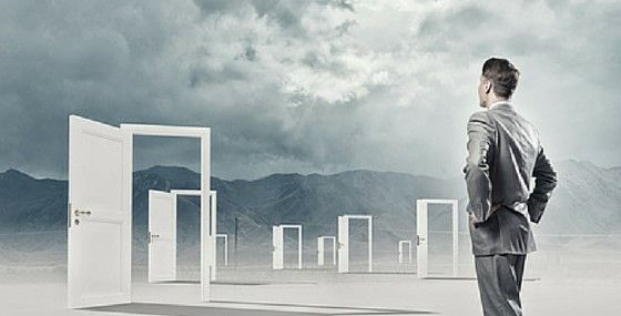 Man in suit standing in front of open doors that lead to nowhere