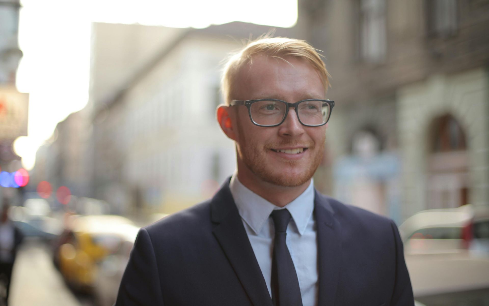 Man in suit and glasses walking in the city