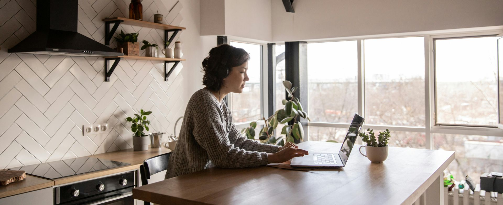 Female working from home on her laptop at her kitchen bench