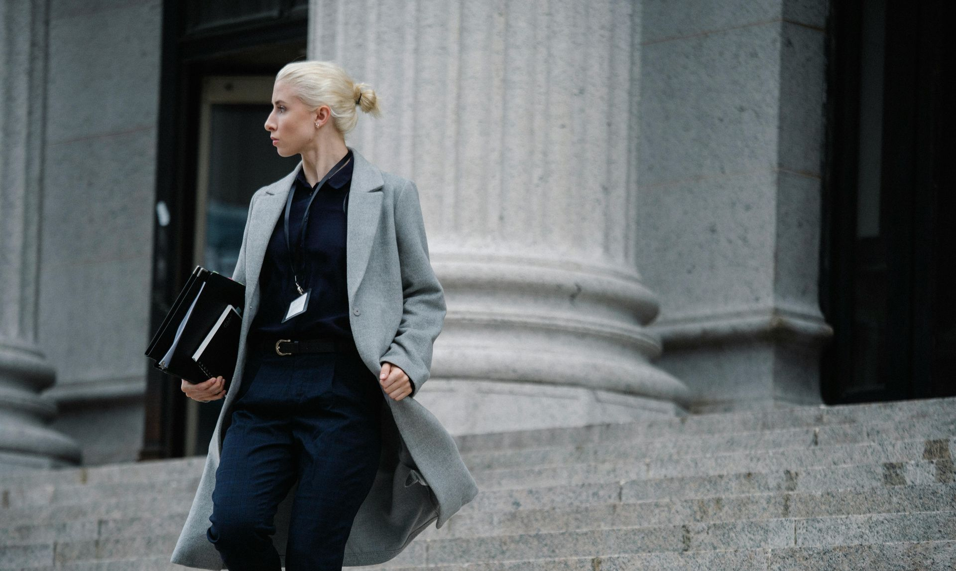 Blonde business woman walking down the steps of a courthouse