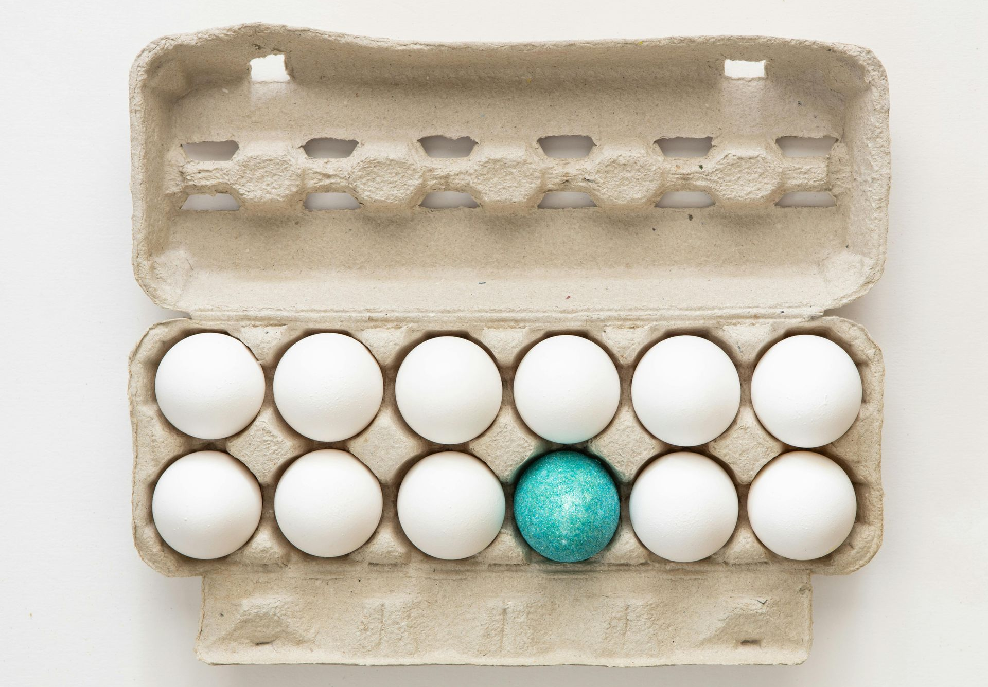 Open carton of eggs - one of the eggs is blue