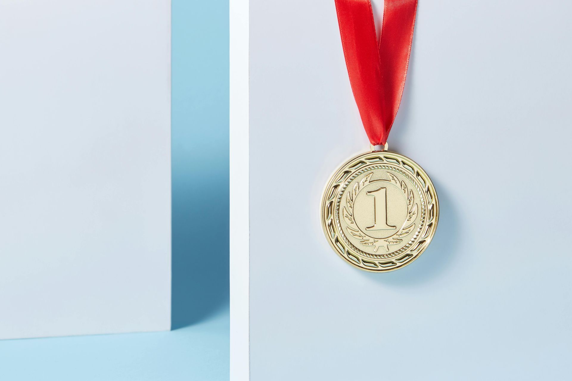Gold medal hanging on a red ribbon