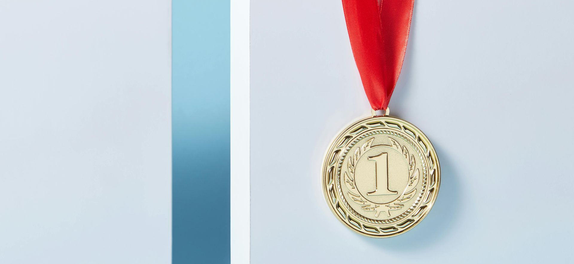 Gold medal hanging on a red ribbon