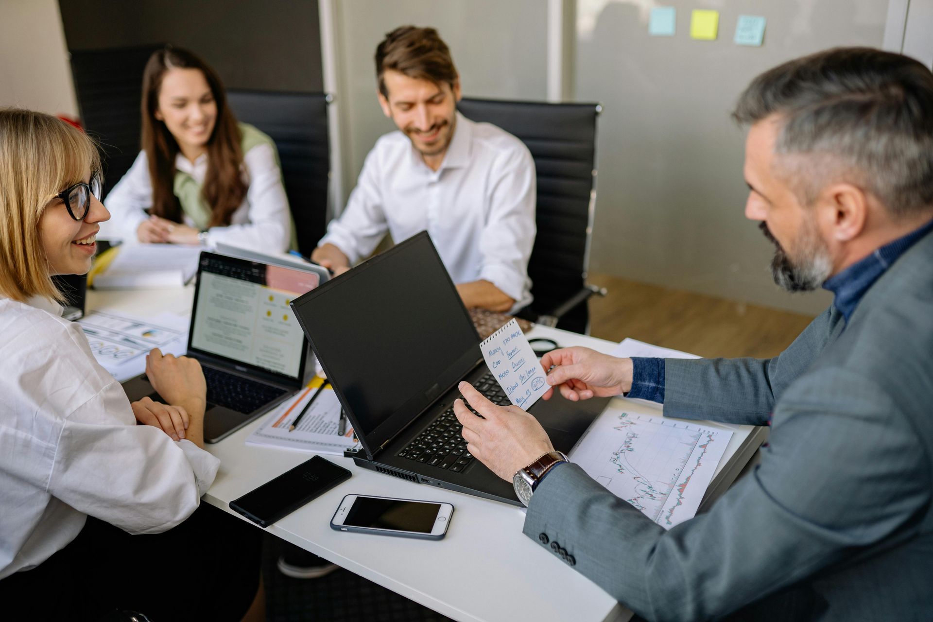 Colleagues in suits sitting at a conference table having a discussion