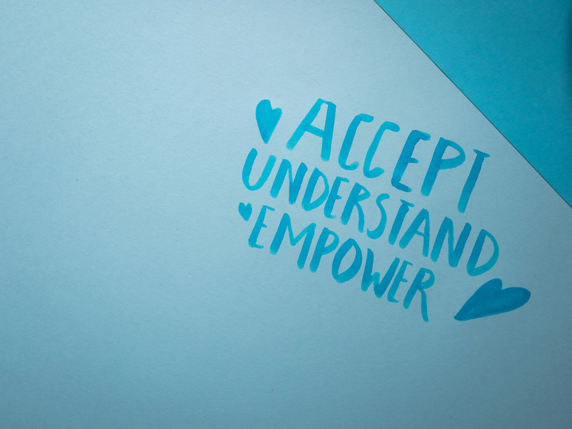 Blue paper with the words 'Accept Understand Empower' written in capitals