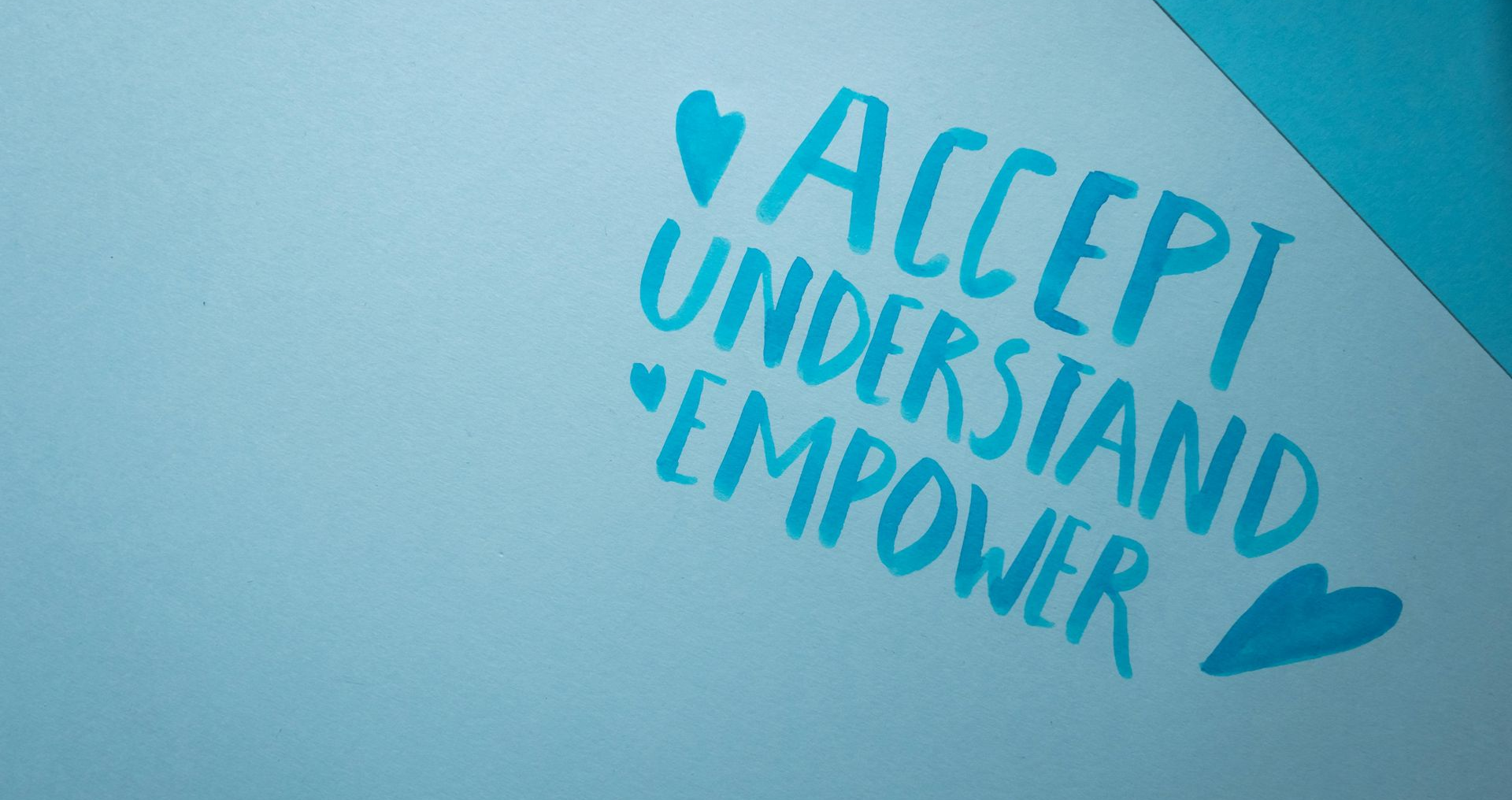 Blue paper with the words 'Accept Understand Empower' written in capitals