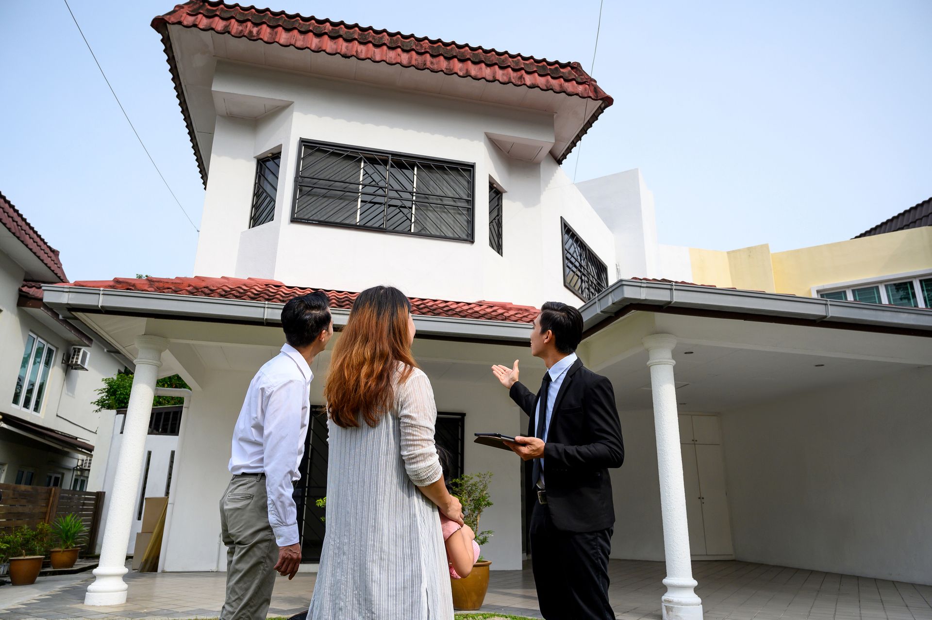 A man in a suit explains coverage to a couple, highlighting the role of a home insurance agent. A man in a suit explains coverage to a couple, highlighting the role of a home insurance agent.