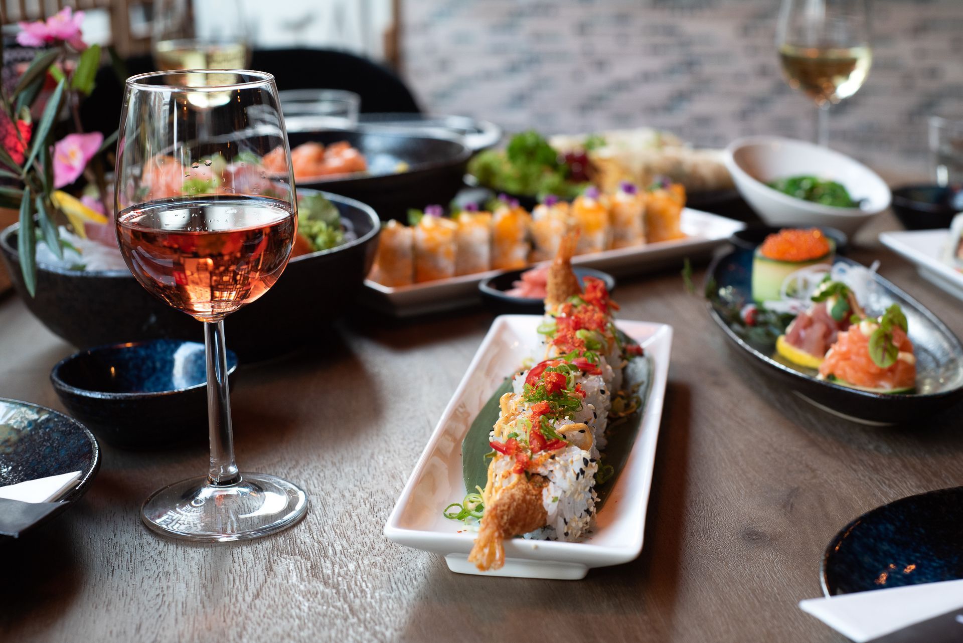 Een tafel met borden vol eten en een glas wijn.
