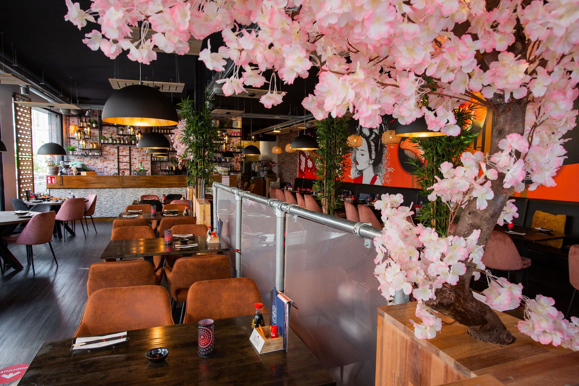 Een restaurant met tafels en stoelen en een kersenbloesemboom op de achtergrond.