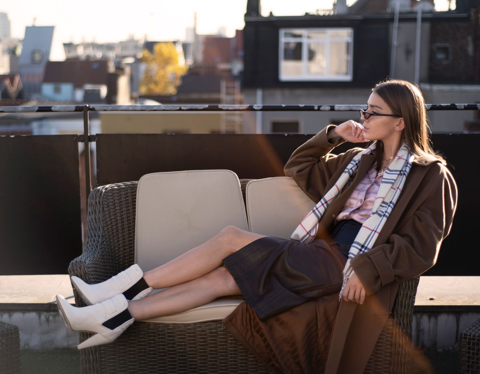 Een vrouw zit op een bank met haar benen over elkaar.