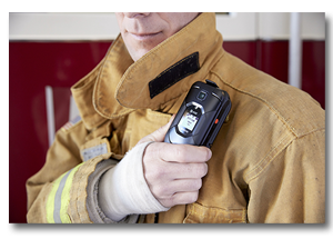 A man in a fire suit is holding a cell phone