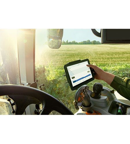 A person is using a tablet while driving a tractor.