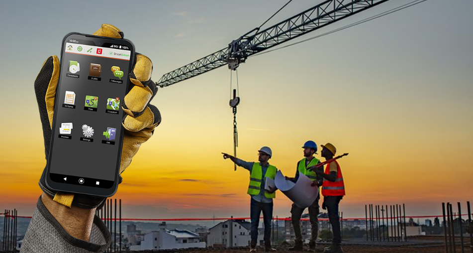 A person is holding a cell phone in front of a construction site.