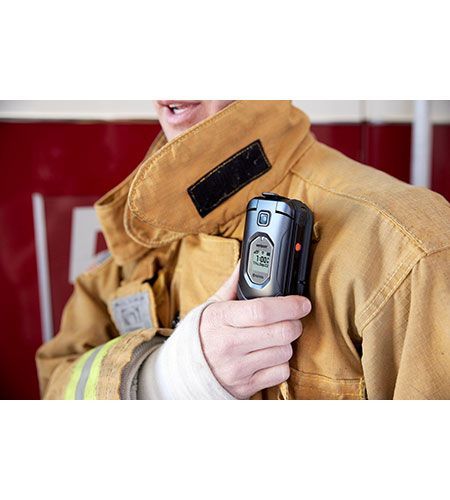 A firefighter is holding a microphone in his hand.