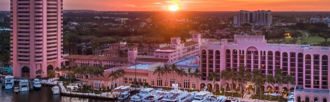 An aerial view of a city with a sunset in the background.