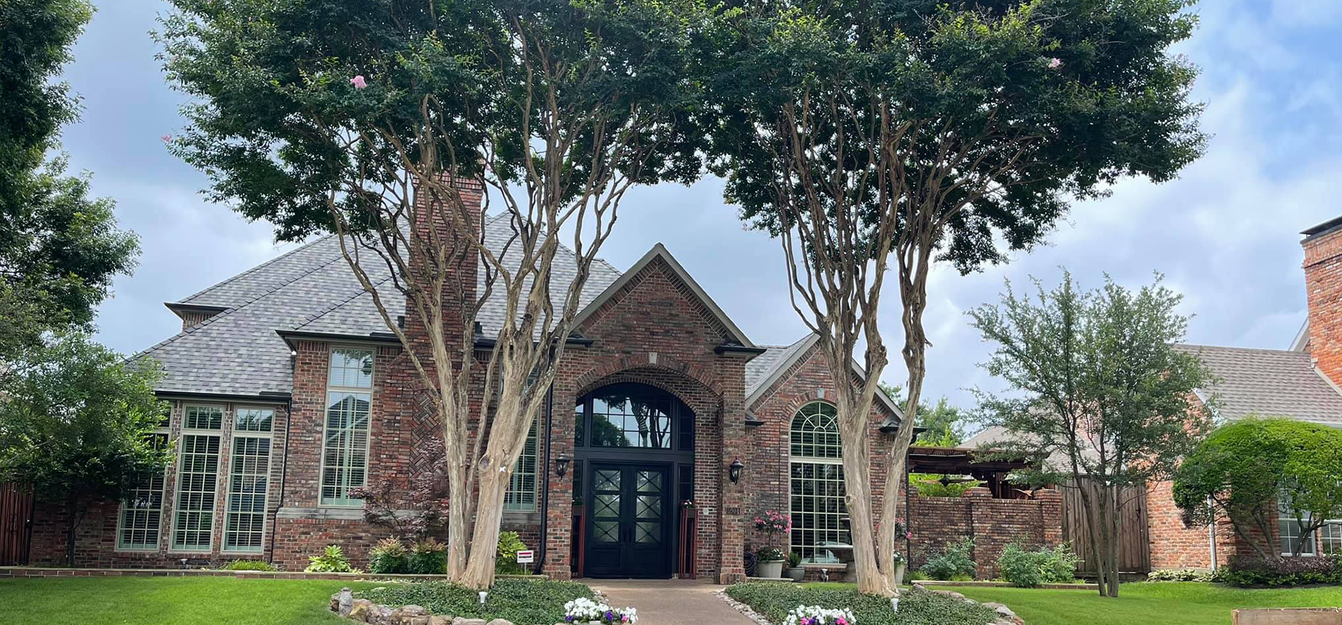 A large brick house with trees in front of it.