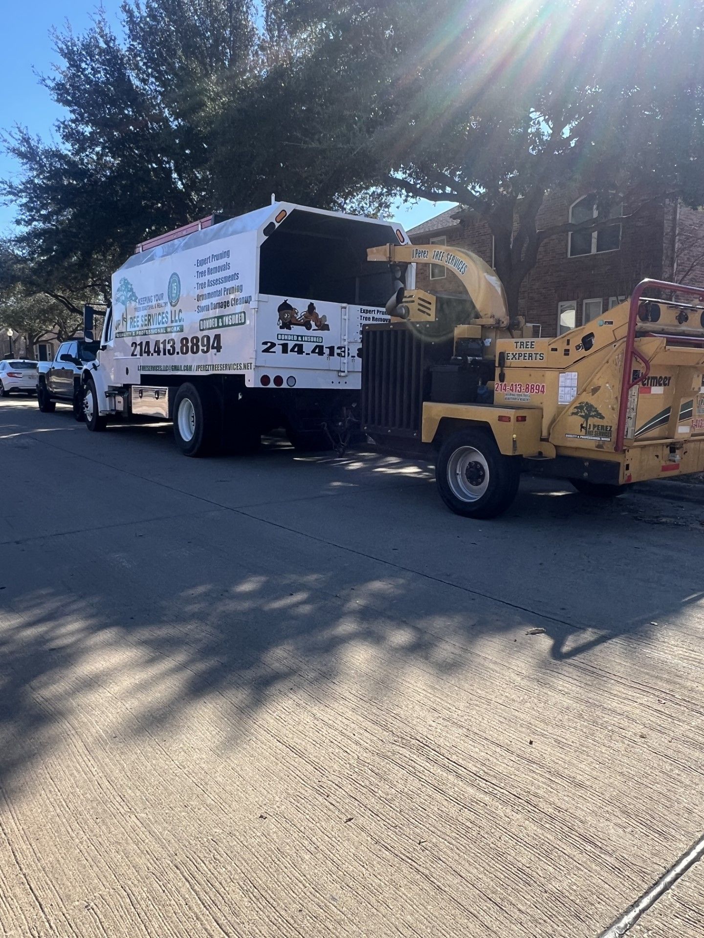 A white truck is parked on the side of the road next to a yellow machine.