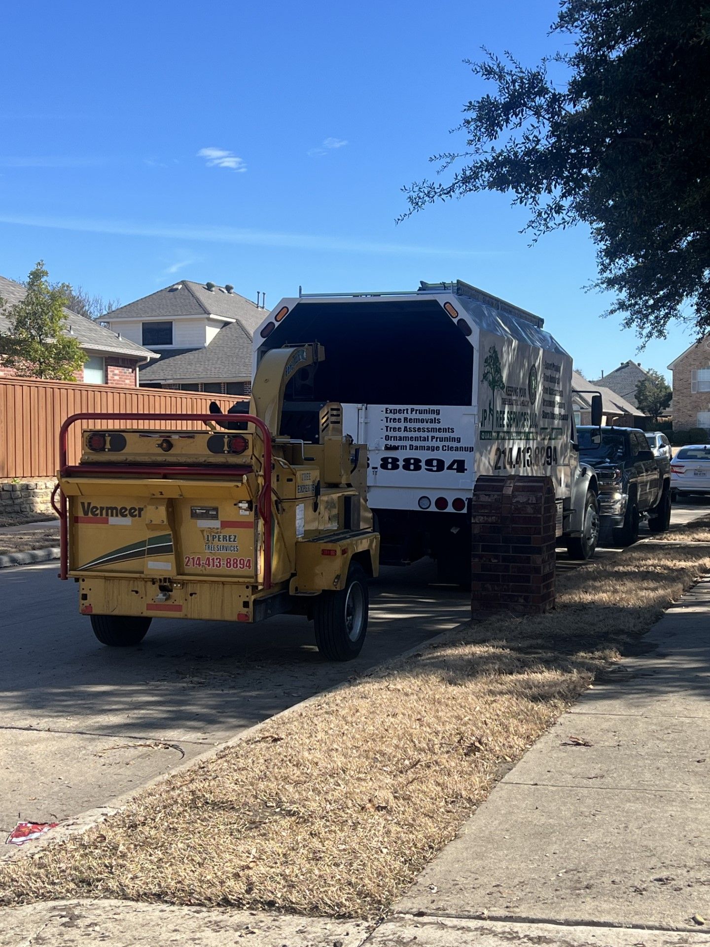 A truck with the word stihl on the back is parked on the side of the road.