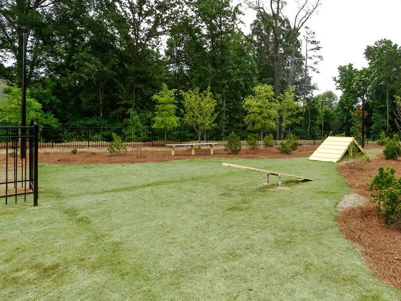 Outdoor community playground with a seesaw, ramp, and grassy area.
