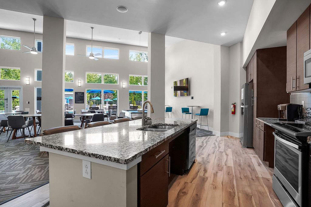 Bright community lounge with a kitchen and large windows.