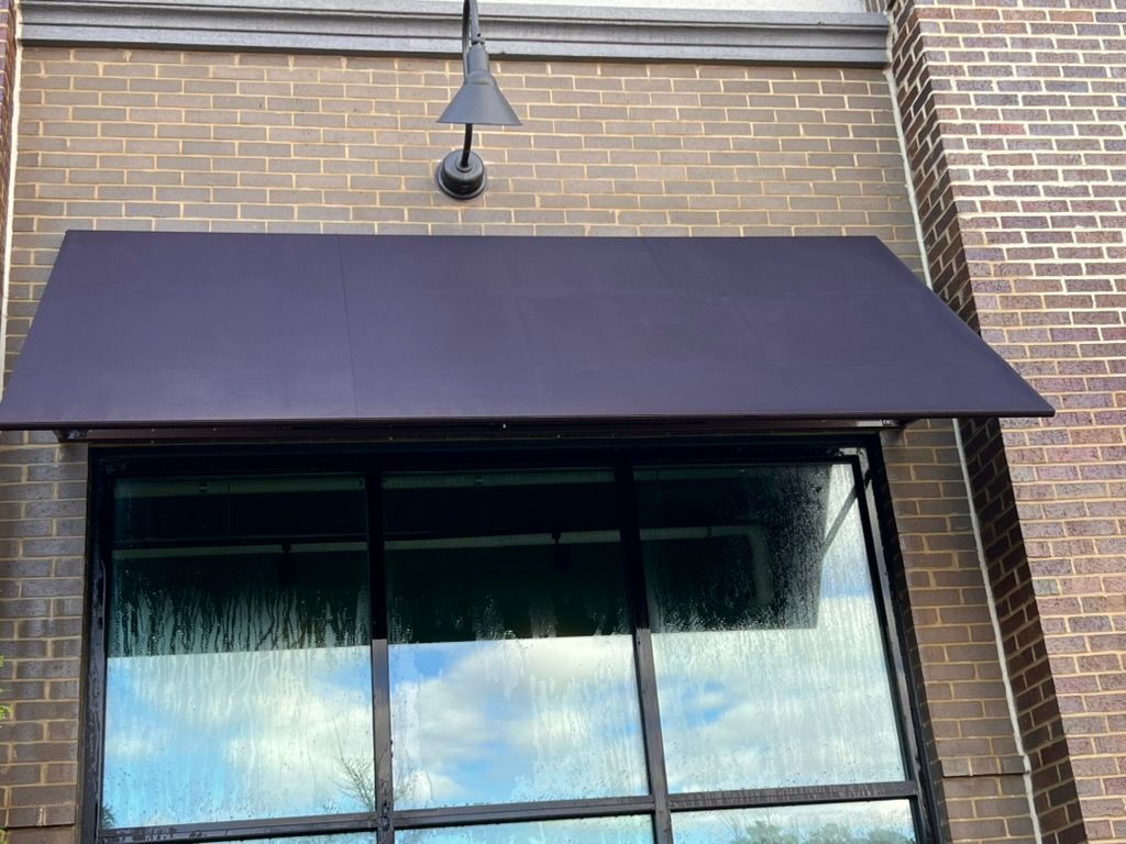 Wooden horizontal blinds, partially closed, showing a glimpse of the outside.