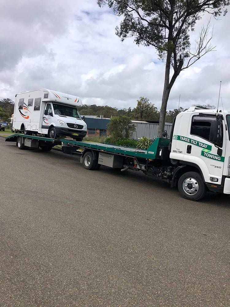 A Tow Truck is Towing a Camper Van Down a Road — Taree Tilt Tray Towing In Harrington, NSW