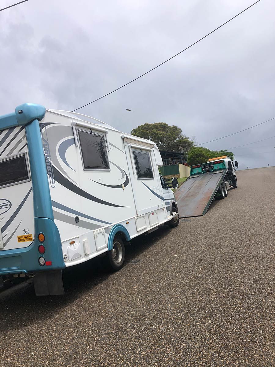 A RV is Being Towed by a Tow Truck — Taree Tilt Tray Towing In Old Bar, NSW