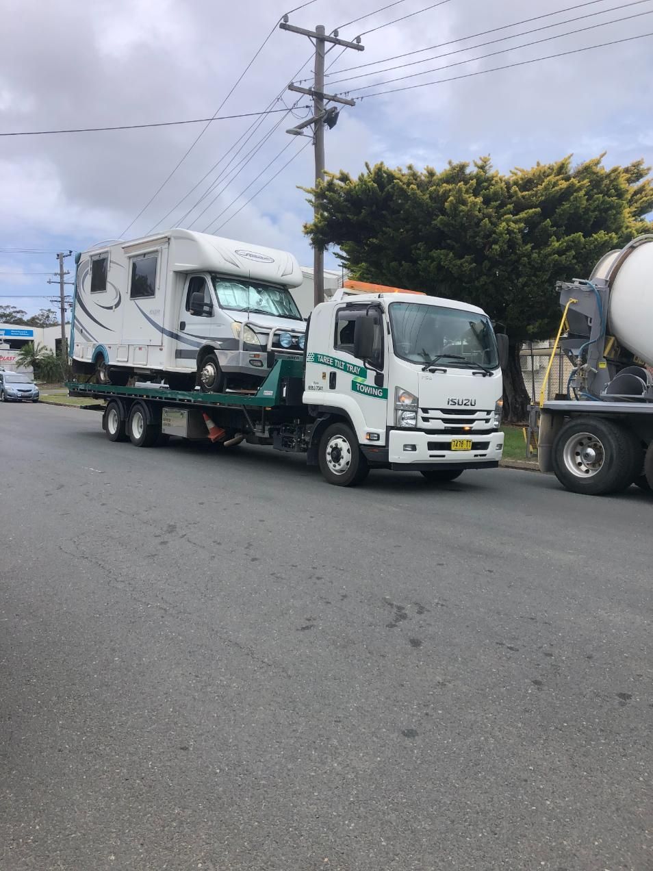 A Tow Truck Is Carrying A Camper On The Back Of It — Taree Tilt Tray Towing In Pampoolah, NSW