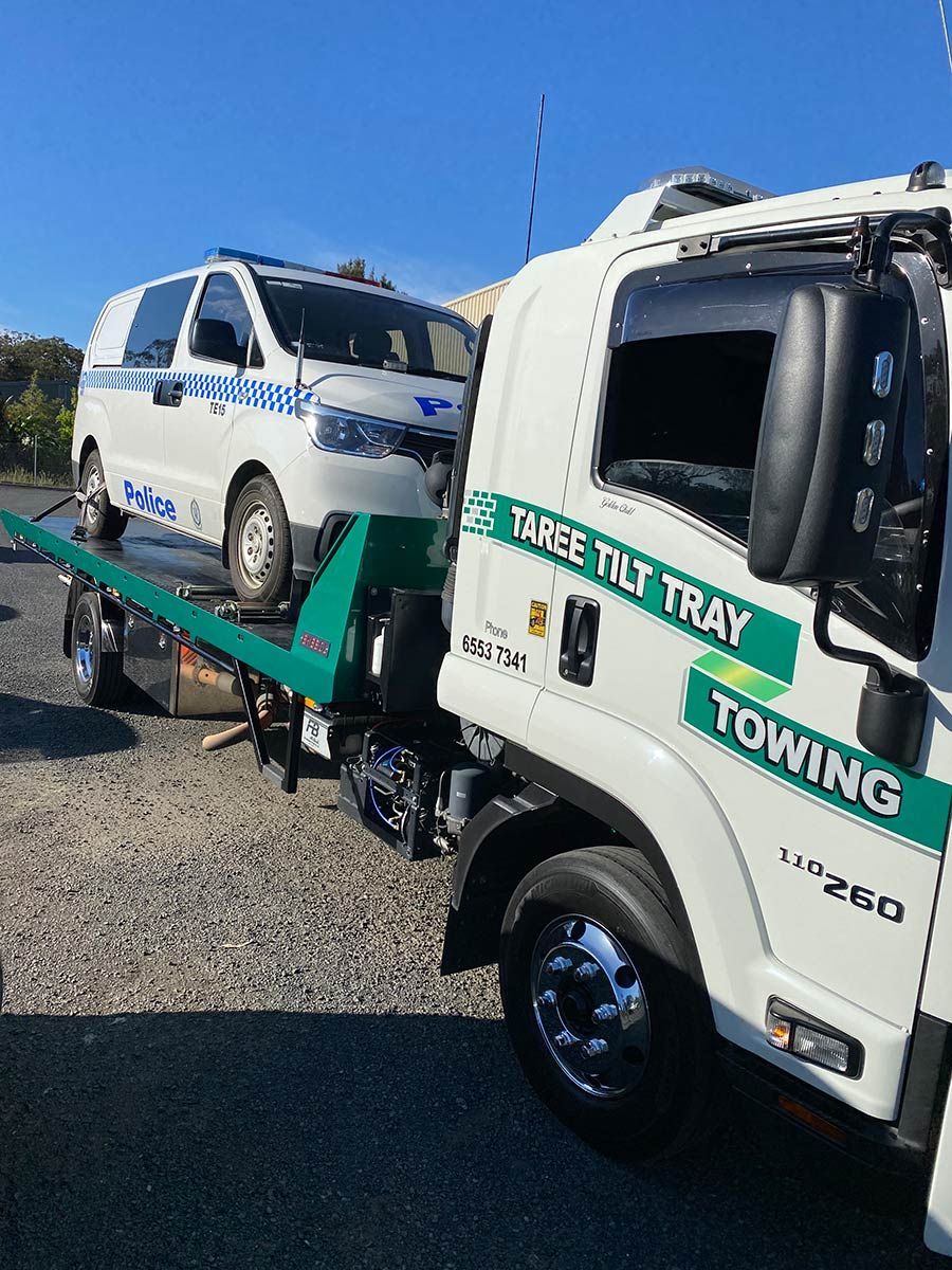 A White Towing Truck Is Towing A White Van — Taree Tilt Tray Towing In Taree, NSW