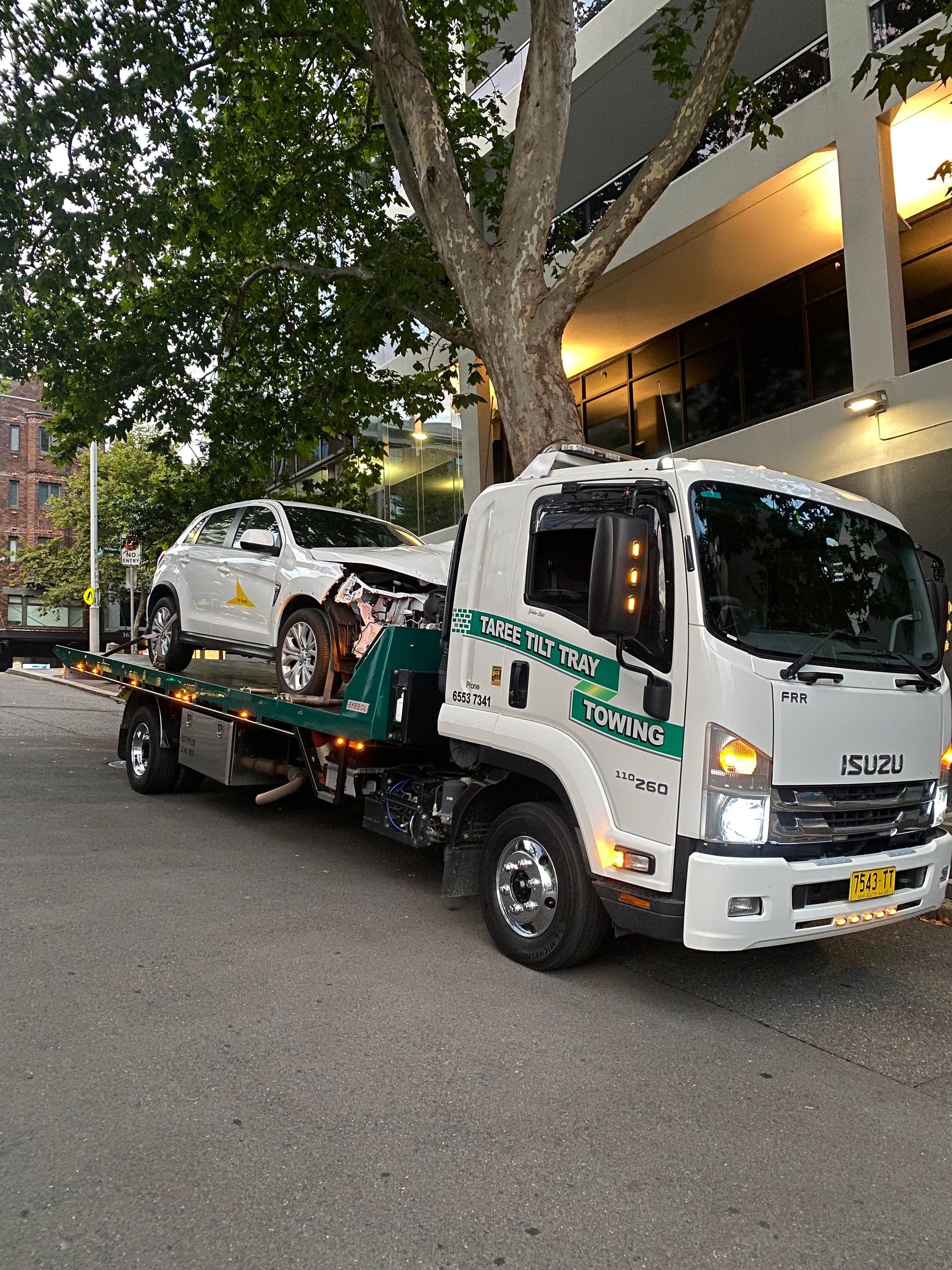 A White Towing Truck is Towing a White Van — Taree Tilt Tray Towing In Pampoolah, NSW