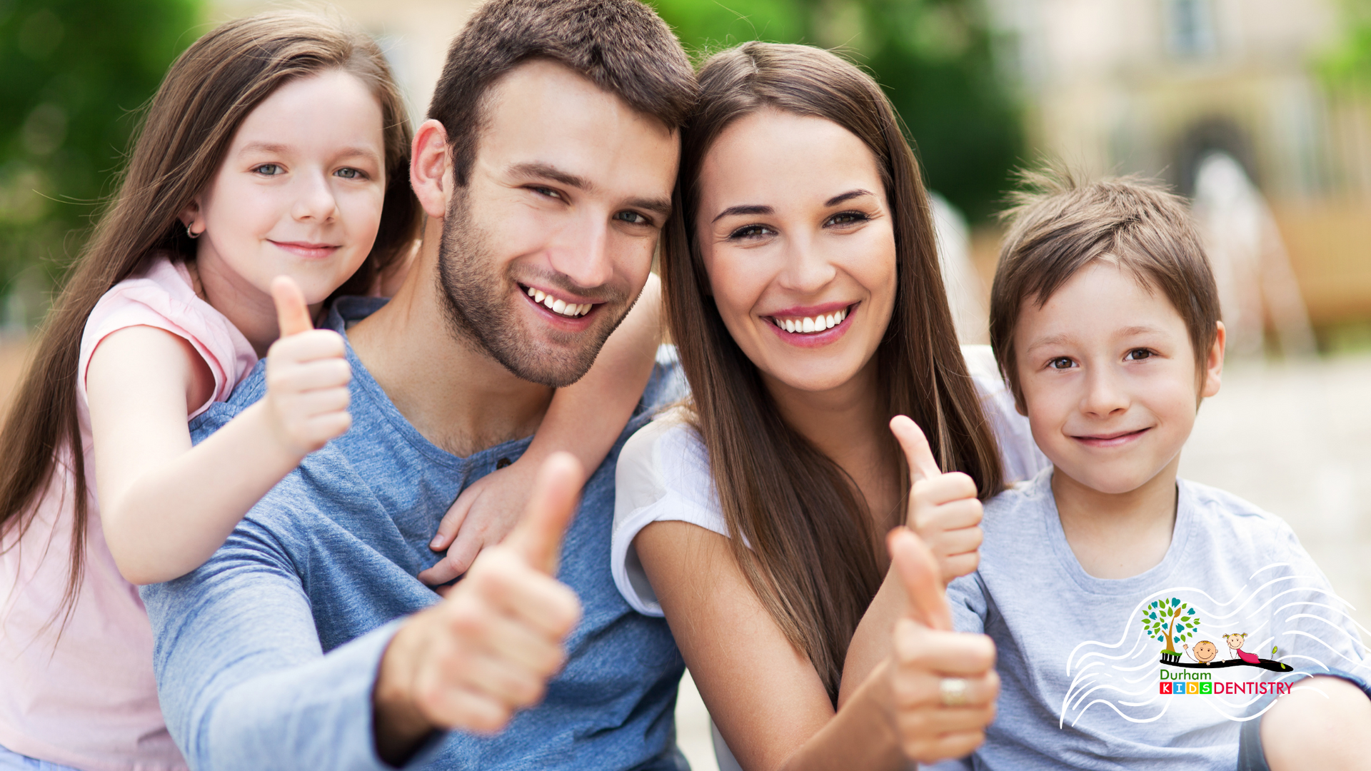 A family is posing for a picture and giving a thumbs up.