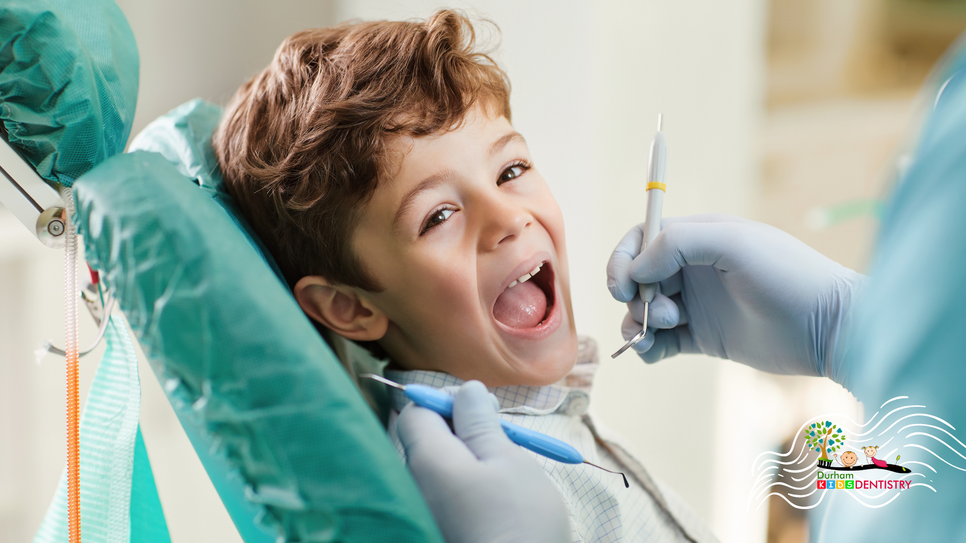 A young boy is sitting in a dental chair while a dentist examines his teeth.