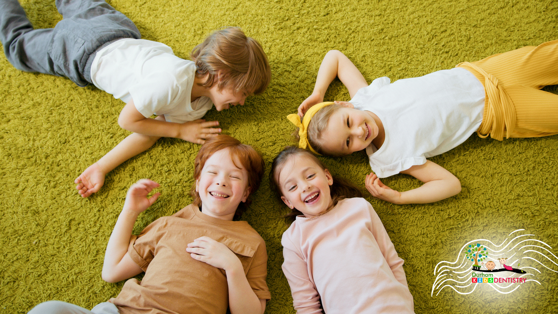 A group of children are laying on the floor in a circle.