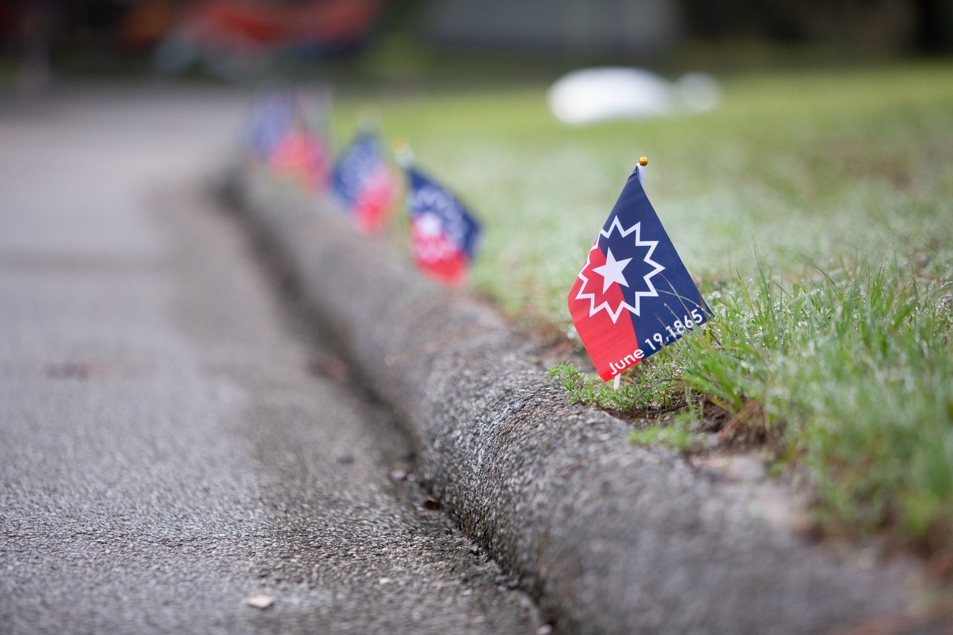 A row of small flags on the side of a road.