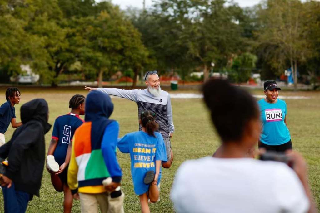 A group of people are standing in a circle in a field.