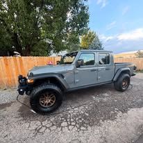 Gray Jeep truck parked on pavement.