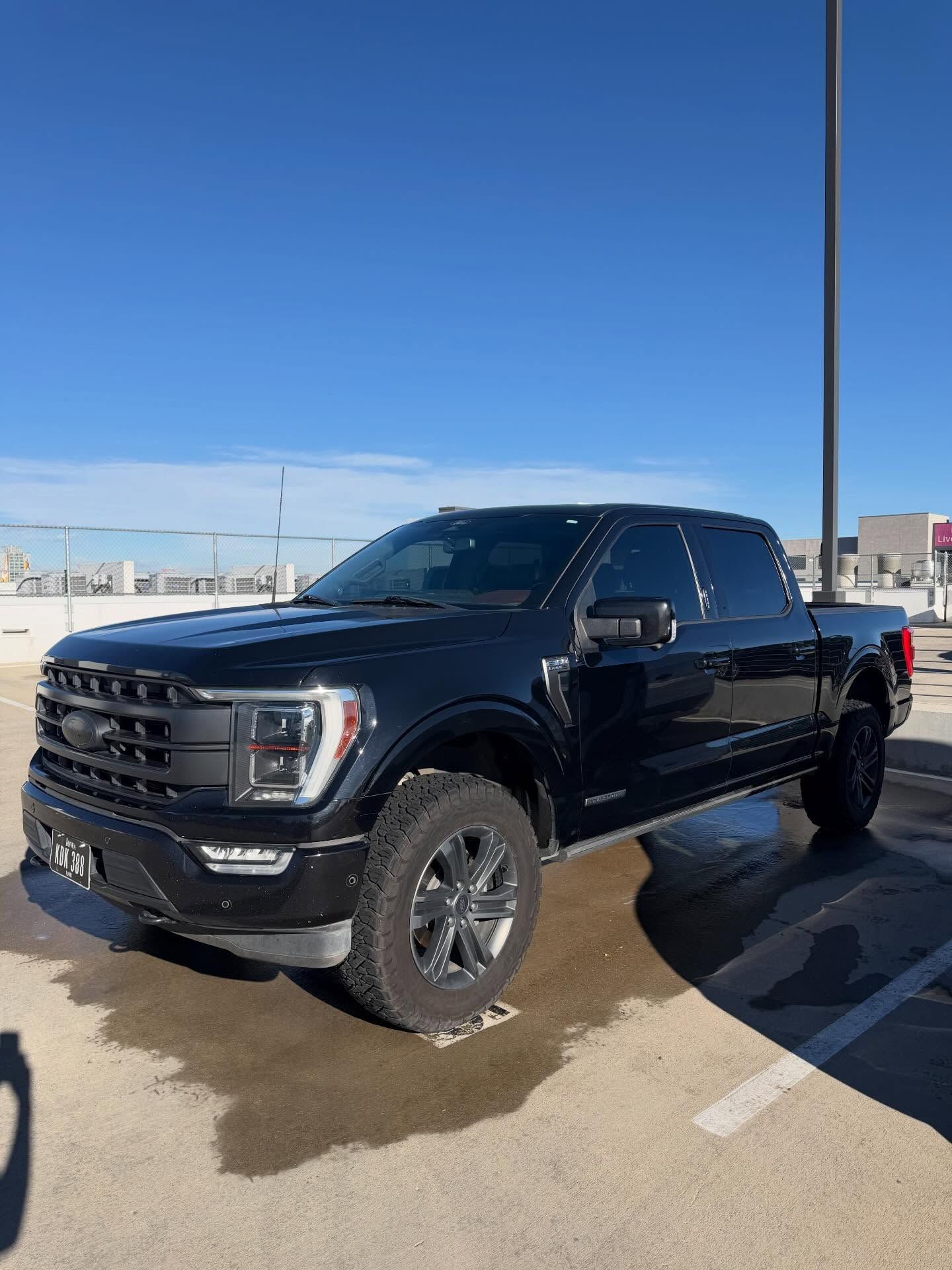 Black Ford F-150 truck parked outdoors on a sunny day.