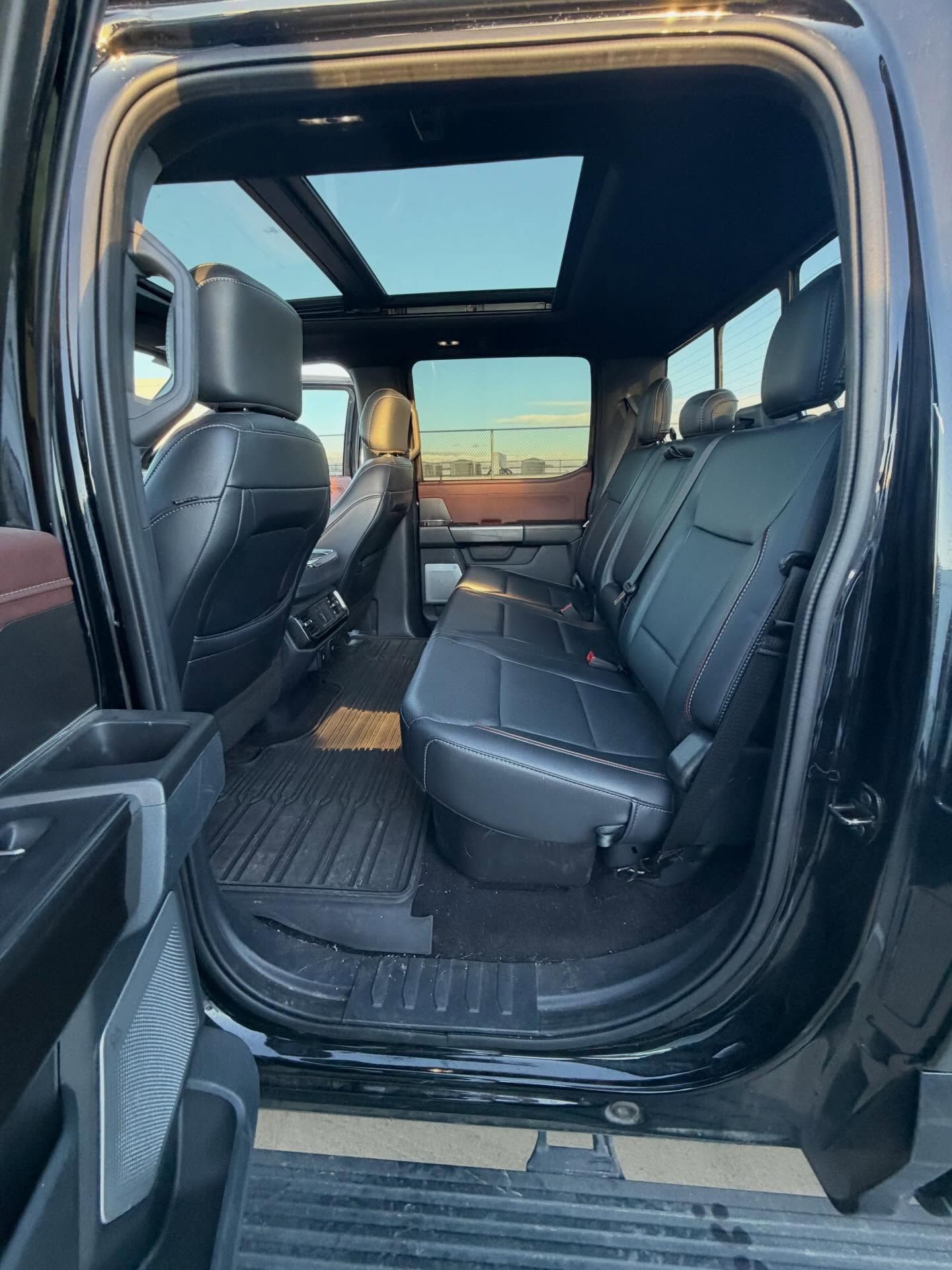 Black truck interior with black leather seats, floor mats, and a sunroof.