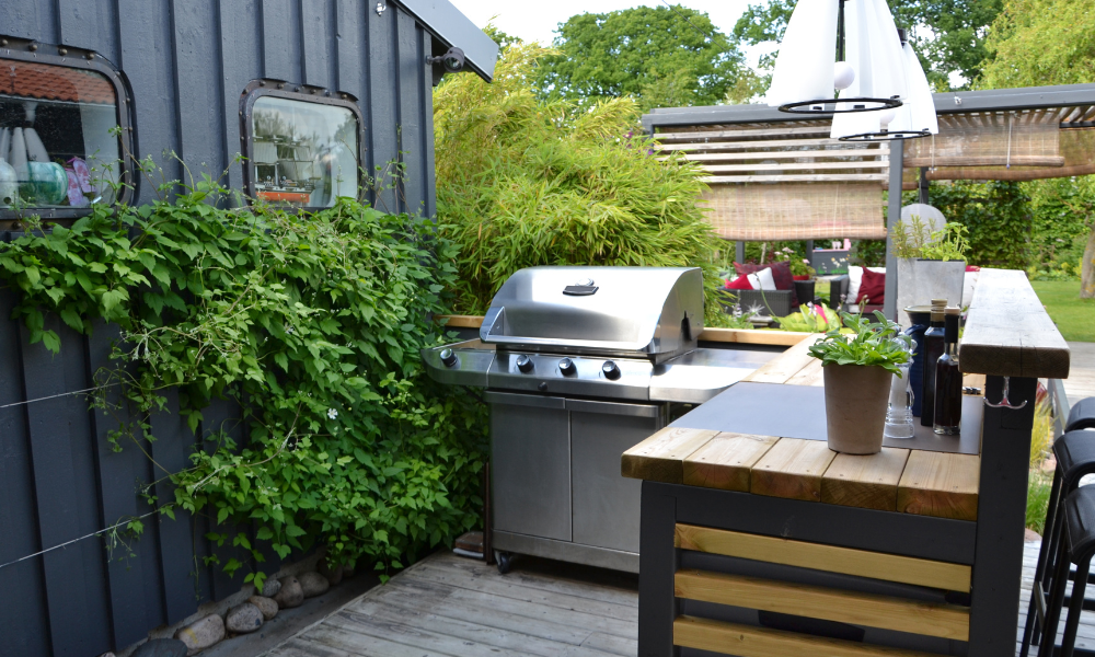A patio with a fire pit and a couch in front of a house