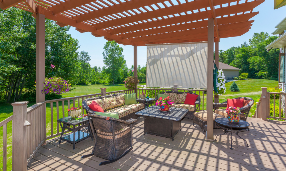 A patio with a fire pit and a couch in front of a house