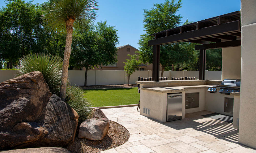 A patio with a fire pit and a couch in front of a house