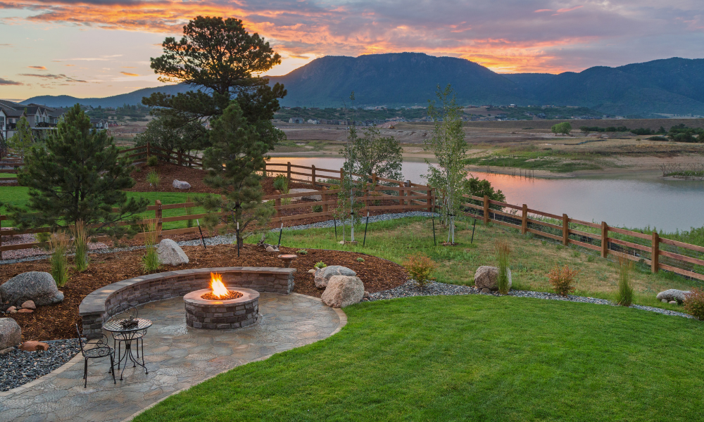 A patio with a fire pit and a couch in front of a house