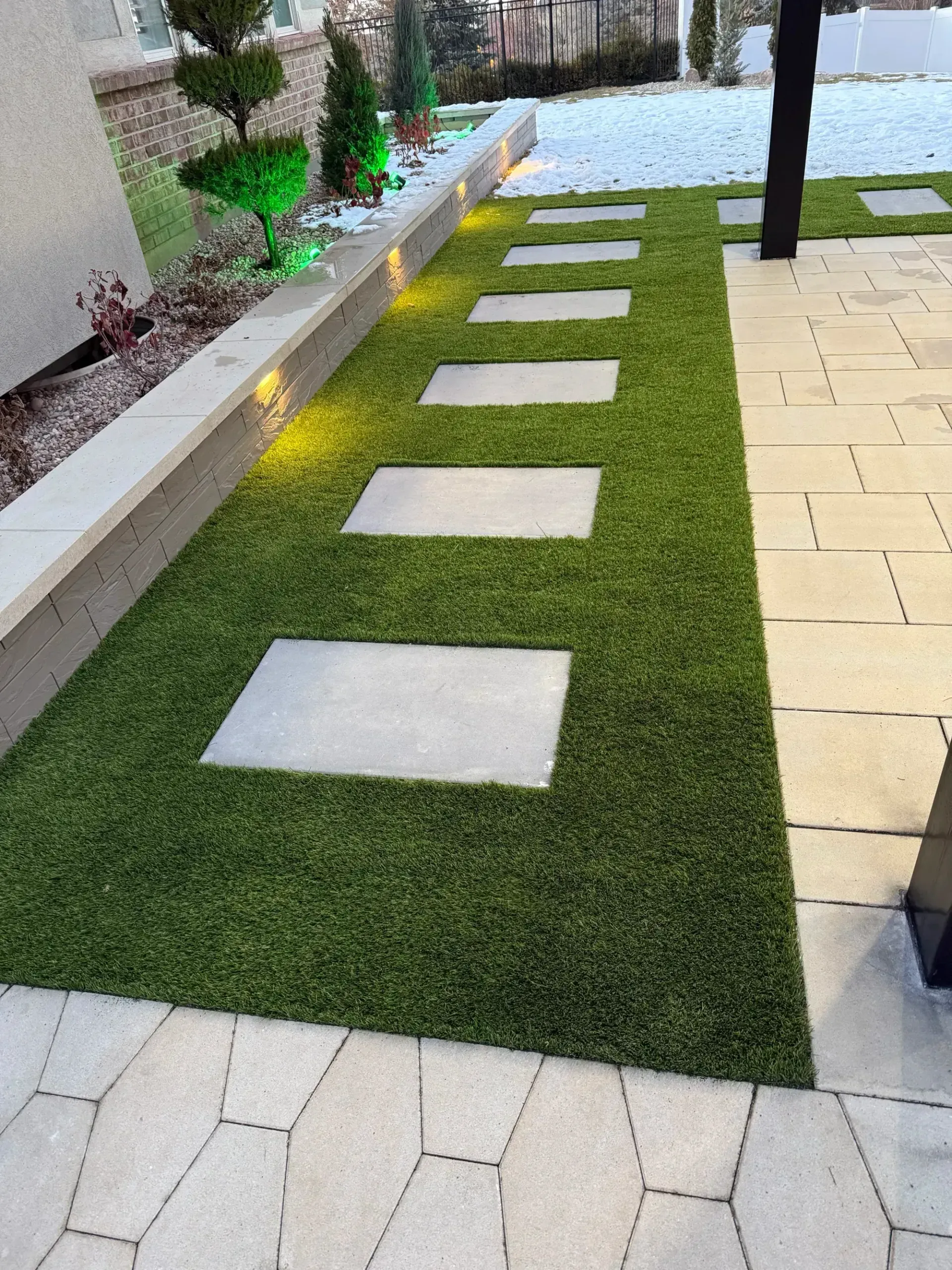 A lawn with a row of stepping stones in it