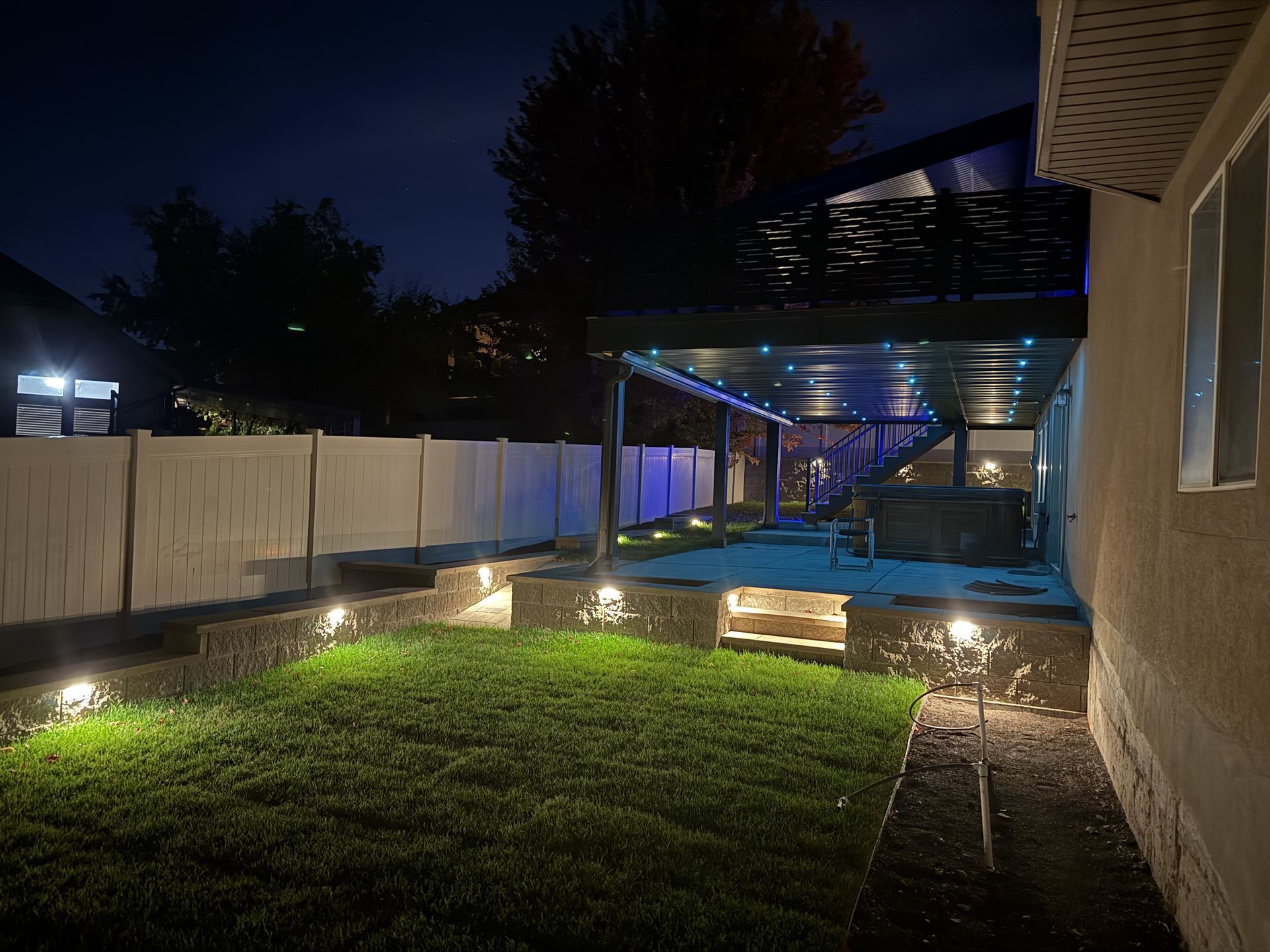 The backyard of a house is lit up at night.