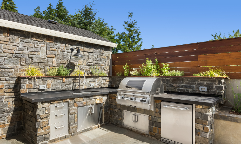 A patio with a fire pit and a couch in front of a house