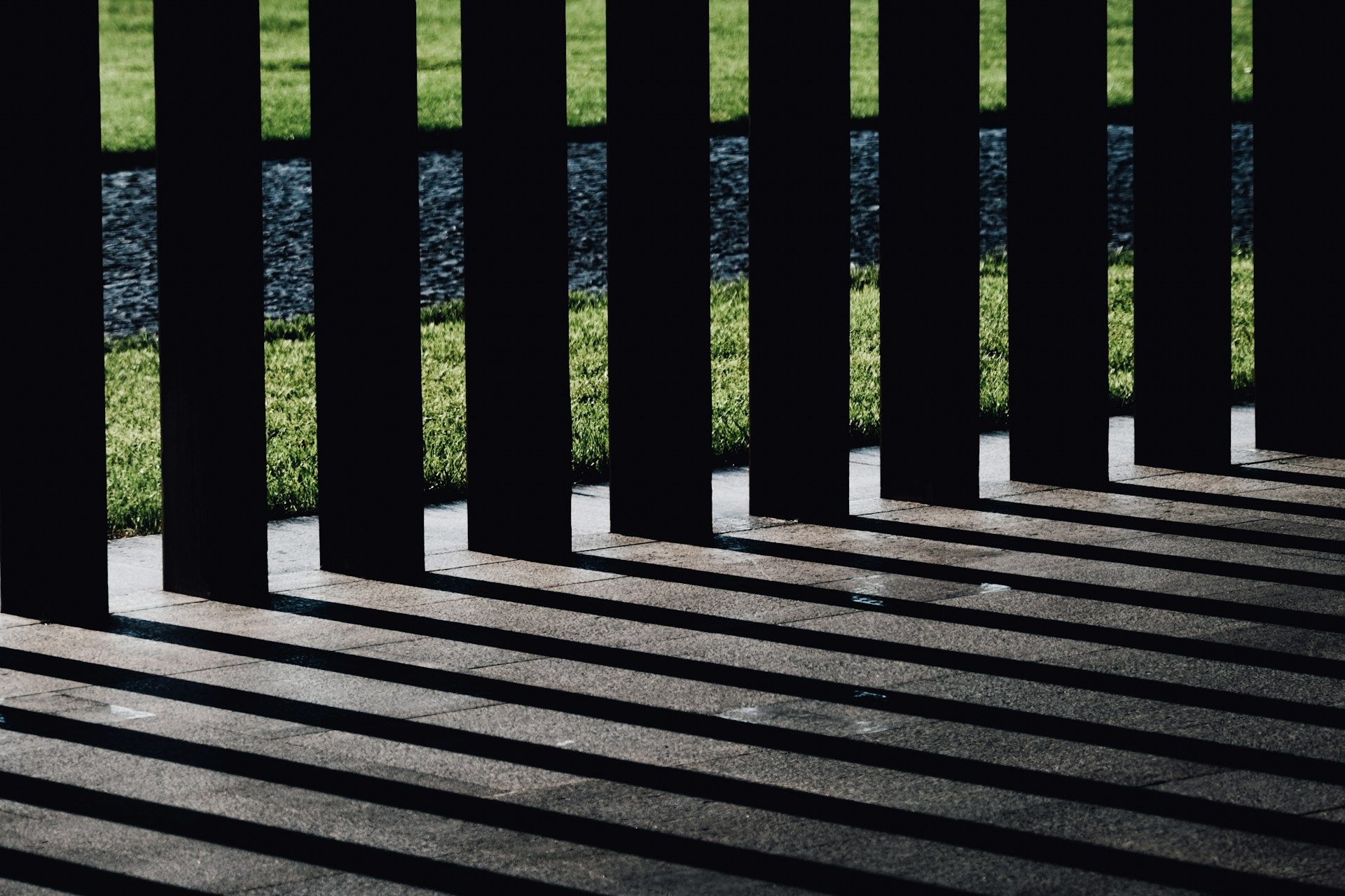 Black fence casting shadows on a concrete surface in State College